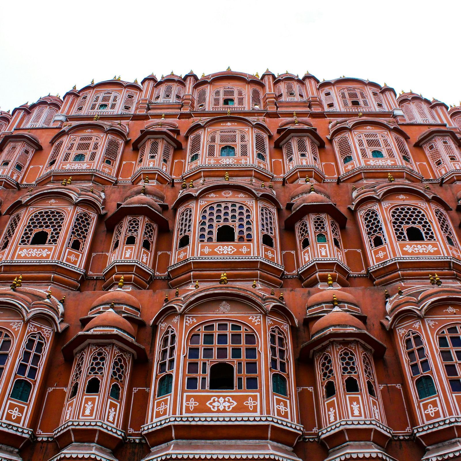 Hawa Mahal in Jaipur, featuring its pink facade and intricate latticework against a clear sky.